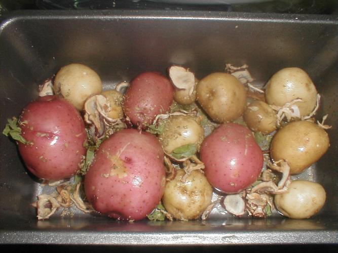Patatas preparadas para asarse con piel en una fuente de horno.