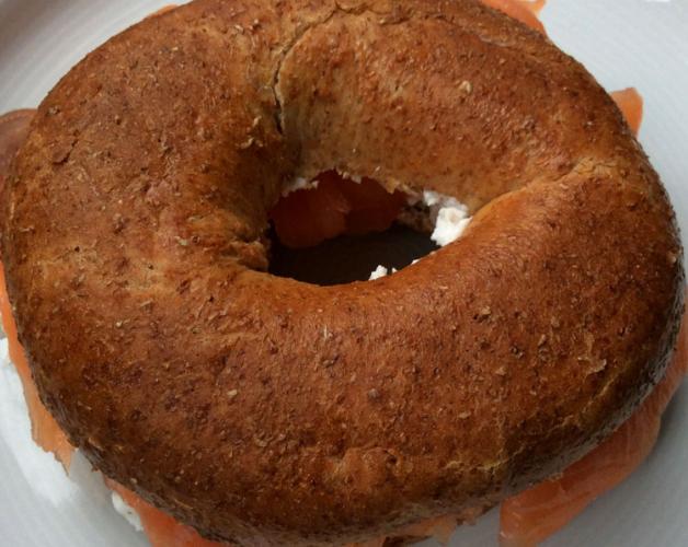 Bagel de hairna integral con salmón ahumado y queso cremoso.
