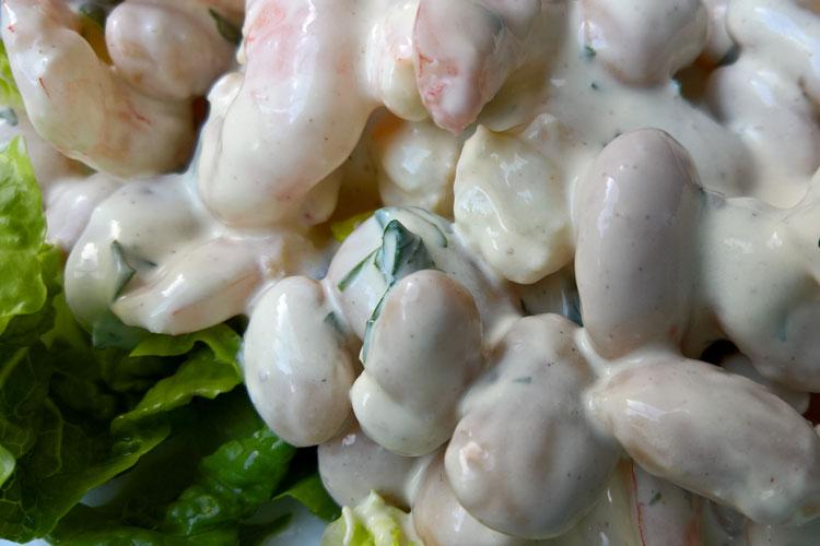 Gambas a la crema servidas sobre lechuga.