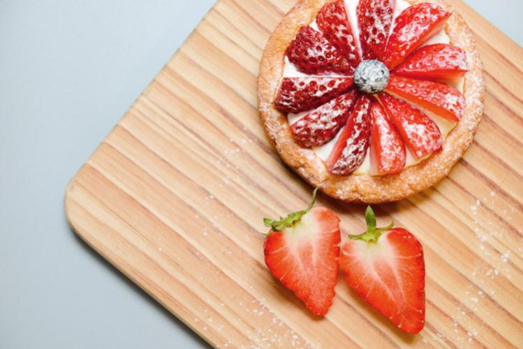Tarta de fresa y crema sobre tabla de madera.