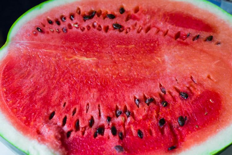 Sandía cortada por la mitad, una fruta de color rojo.