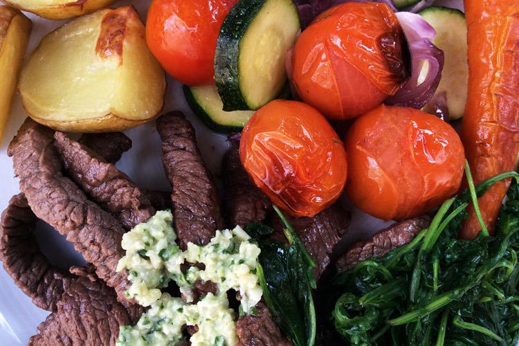 Filete con salsa de piñones y rúcula con hortalizas asadas.
