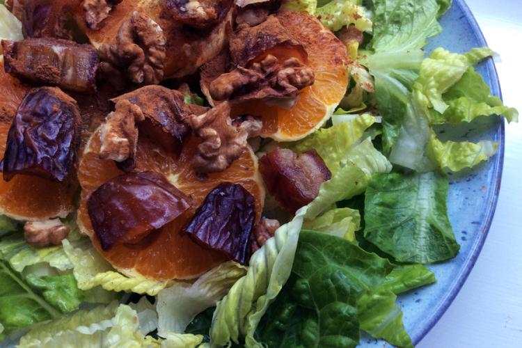 Ensalada con nueces, dátiles y naranja aliñada y condimentada con canela.
