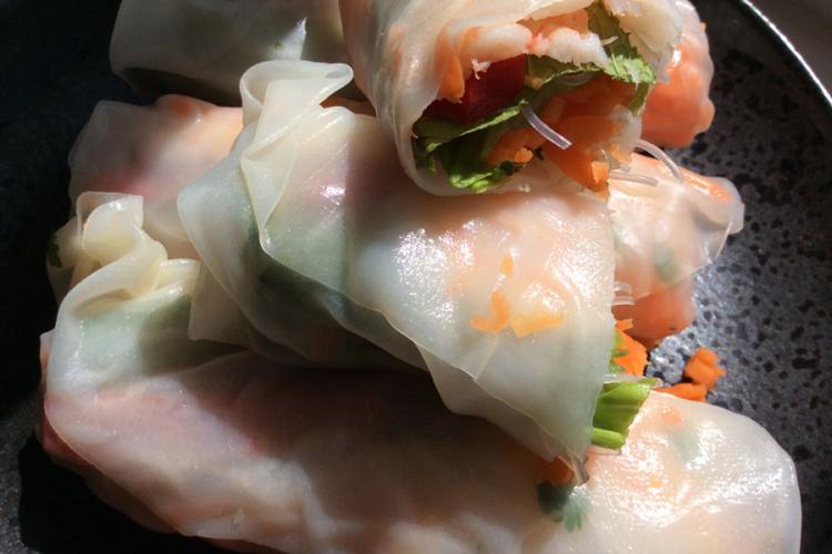 Detalle de rollitos vietnamitas rellenos de ensalada y gambas cocidas.