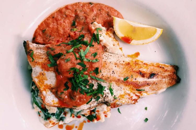 Pescado a la parrilla con salsa de tomate.
