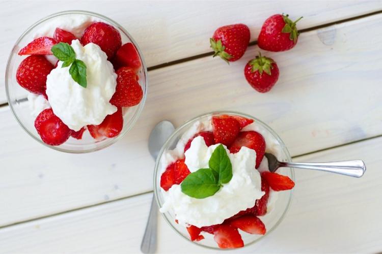 Fresas remojadas en vino con nata montada en copas individuales.