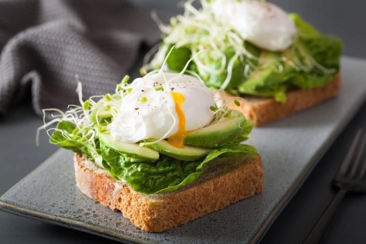 Pan con lechuga, aguacate, brotes de alfalfa y huevo escalfado.
