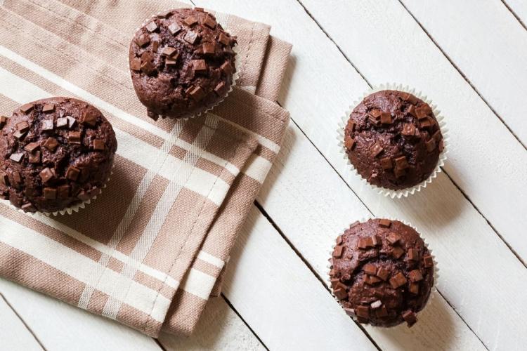 Bizcochitos de chocolate con pepitas de chocolate sobre una mesa de madera con un trapo de cocina.