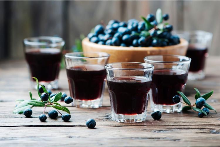 Vasos con mirto rojo alrededor de un recipiente con bayas de mirto.