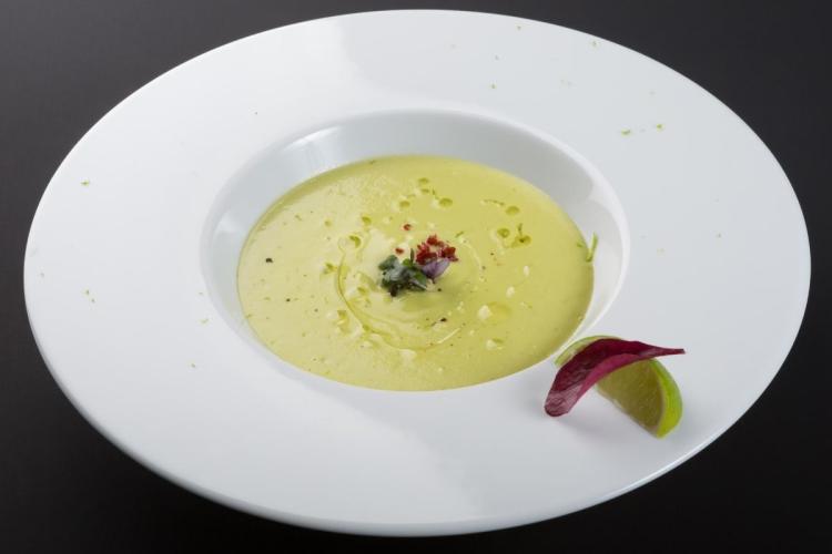 Crema de aguacate fría decorada con lechuga y lima.