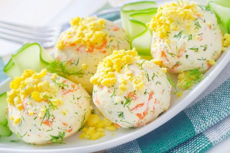 Bolas de queso y zanahoria decoradas con hierbas, yema de huevo y tiras de pepino.