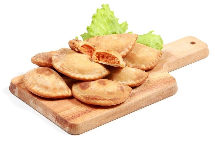 Empanadillas sobre una tabla de madera.