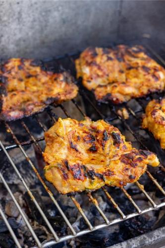 Pollo al yogur cocinándose sobre las brasas.