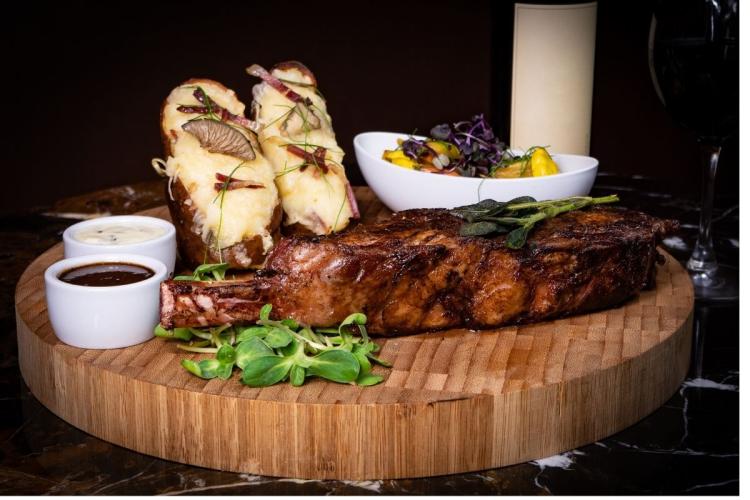 Filete de búfalo, o bisonte americano, a la parrilla servido con salsa y guarniciones.