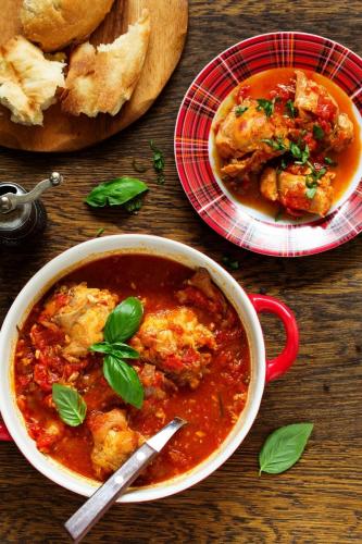 Conejo con tomate y albahaca en una cazuela.