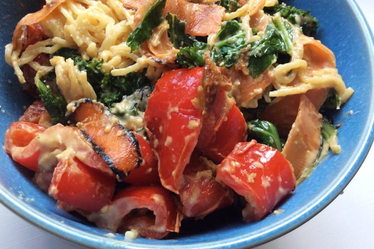 Cuenco con fideos chinos con verduras salteadas y salsa de cacahuete.