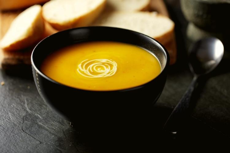 Un cuenco con puré de hortalizas decorado con nata agria.