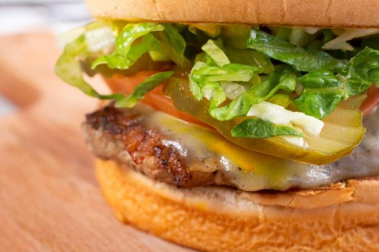 Detalle de una hamburguesa de pavo servida en un bollo con los ingredientes tradicionales.