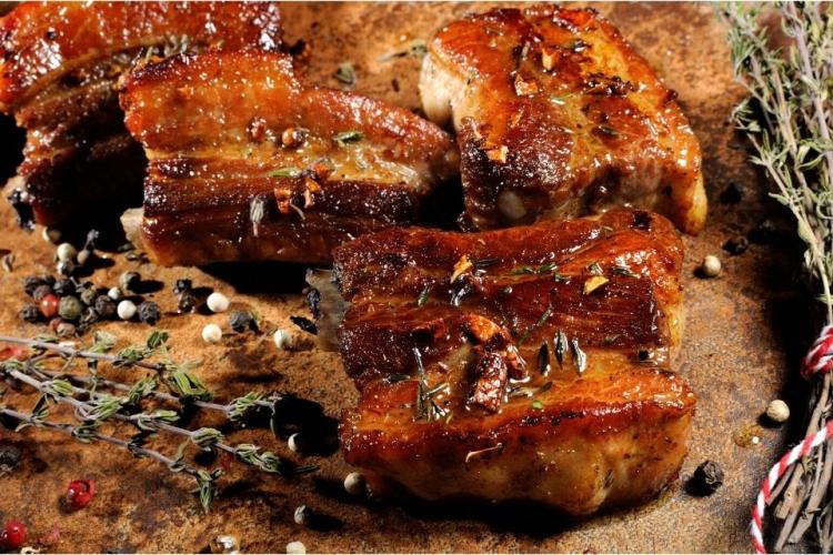 Costillas de cerdo aromatizadas con tomillo, pimienta, ajo y comino, ya fritas.