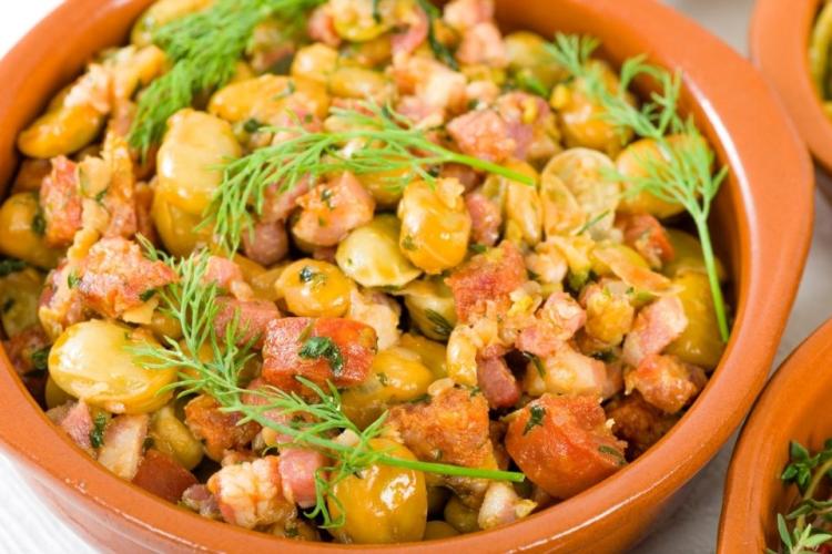 Habas con chorizo y jamón serrano, al estilo salmantino, en una cazuelita de barro.