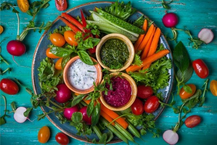 Crudités incluyendo tomates enanos, hierbas y tres salsas.