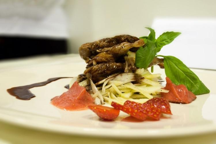 Codorniz con salsa al chocolate en un plato con su guarnición.