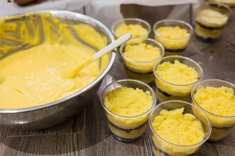 Repartiendo crema helada de coco y mango entre recipientes individuales.