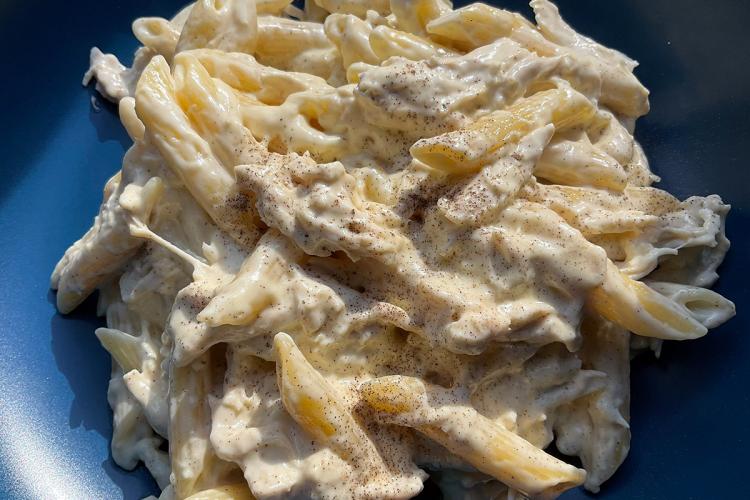 Un plato de pasta con pollo a la chilena con iluminación natural.