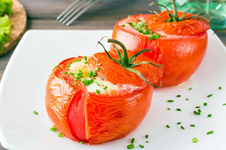 Tomates rellenos con huevos hechos en el horno.