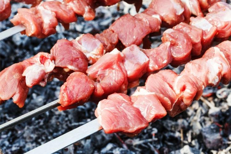 Shish kebabs de cordero empezando a cocinarse sobre las brasas de la barbacoa.