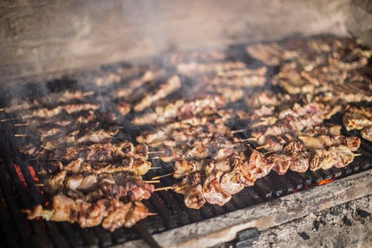 Souvlaki cocinándose en una parrilla sobre las brasas.
