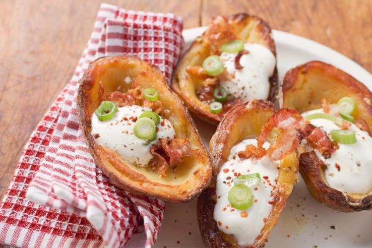 Cáscaras de patata con tocino entreverado frito, nata líquida y cebollino.