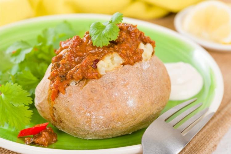 Una patata asada cubierta de chile con carne.