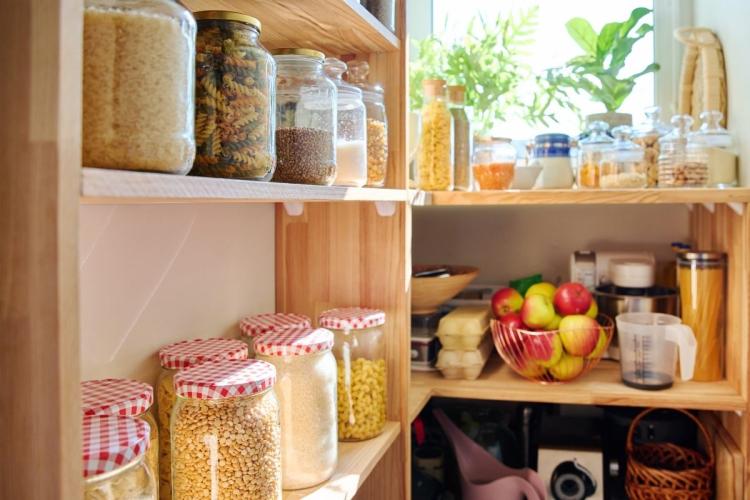 Despensa con alimentos almacenados en tarros de vidrio colocados en estantes.
