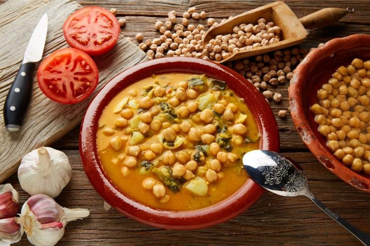 Una cazuela de barro con potaje de garbanzos y espinacas.