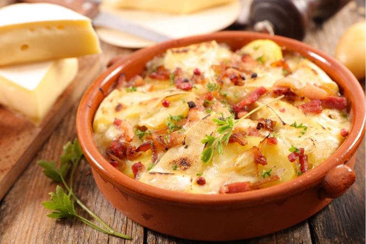 Patatas cortadas en láminas finas horneadas con queso y panceta.