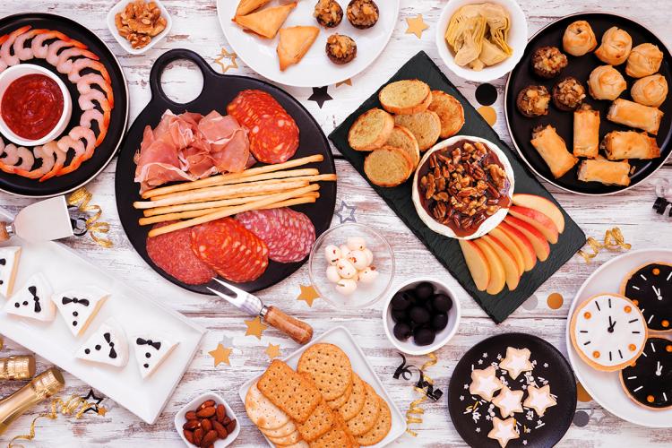 Una mesa con varias tablas para picar para una celebración de fin de año.