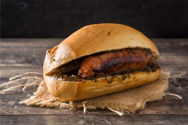 Choripan, un bocadillo de chorizo frito, o asado, servido con chimichurri.