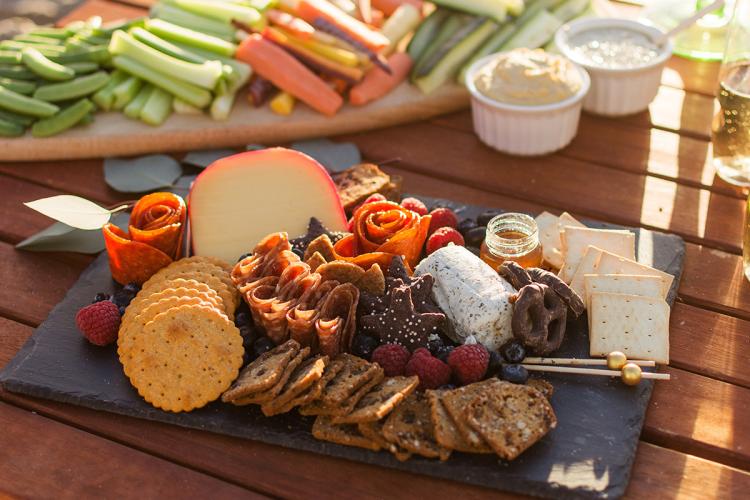 Mesa veraniega con quesos, embutidos y crudités.