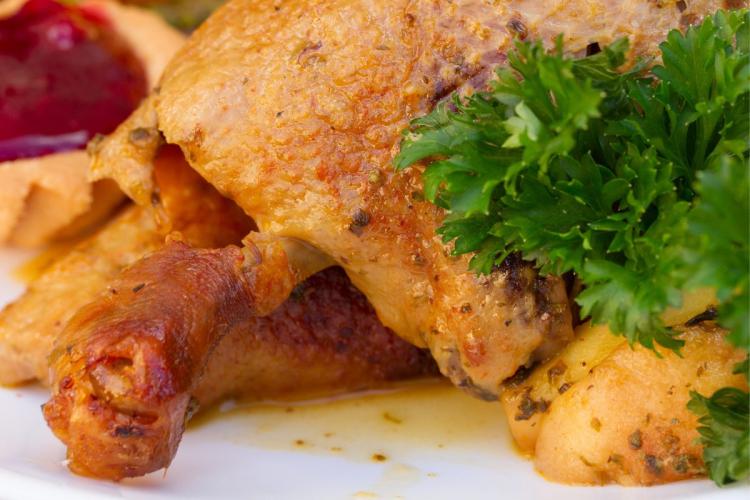 Detalle de pato cocinado con manzanas.