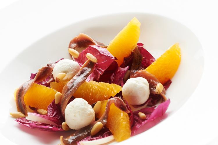 Ensalada de endibias moradas con anchoas, naranja, queso mozzarella y piñones.
