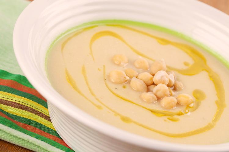 Crema especiada de garbanzos decorada con aceite de oliva y garbanzos cocidos.