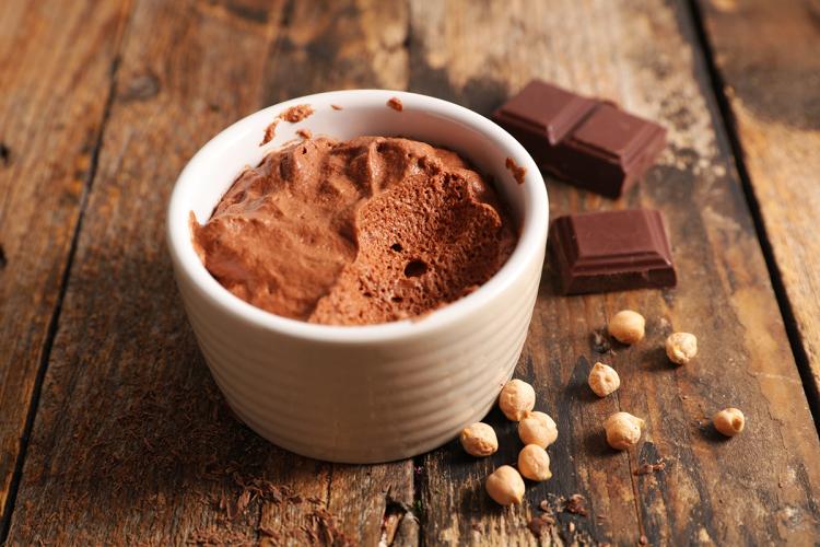 Un recipiente con mousse vegano de chocolate oscuro hecho con aquafaba.