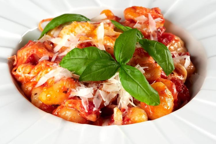 Ñoquis con tomate a la sorrentina decorados con albahaca fresca.