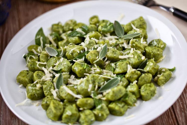 Ñoquis de espinacas con salvia y queso rallado.
