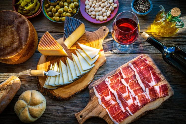 Tapas ordinarias con jamón serrano, queso manchego, aceitunas, almendras y guindillas encurtidas.