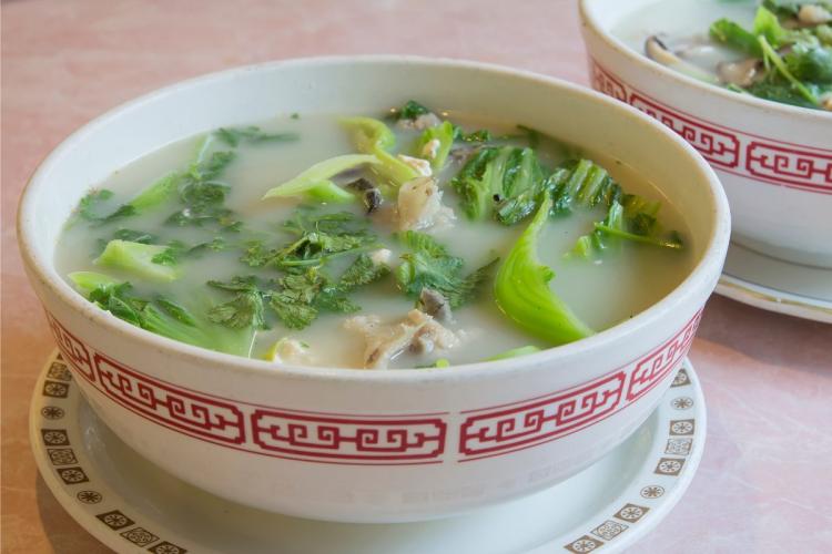 Sopa de cabeza de pescado con verduras y trozos de la cabeza de pescado.