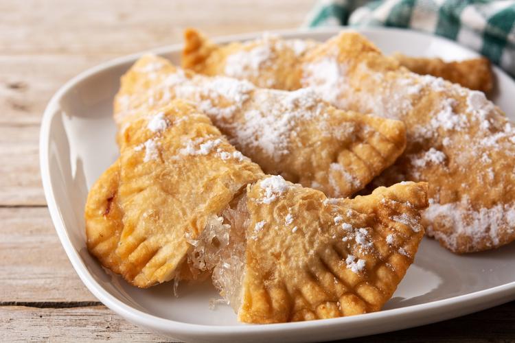 Empanadillas dulces con relleno de cabello de ángel con una empanadilla abierta, mostrando su relleno.
