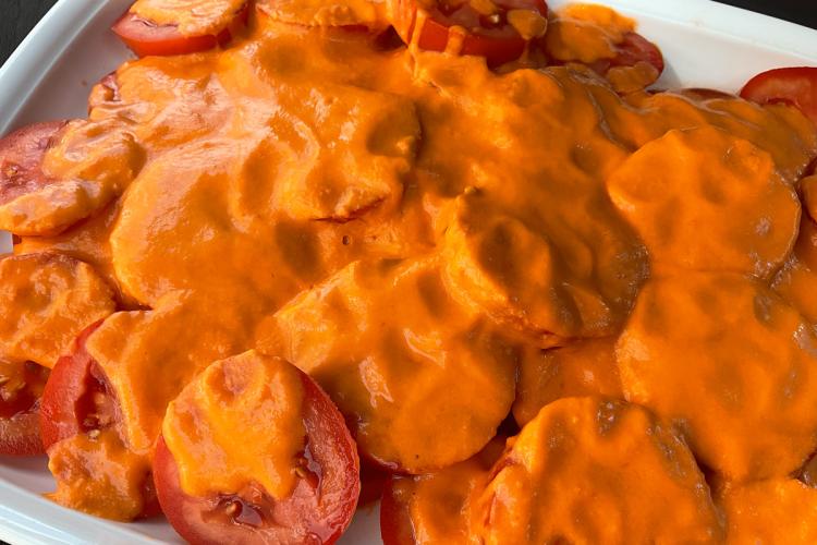 Una fuente de loza blanca con ajotomate.