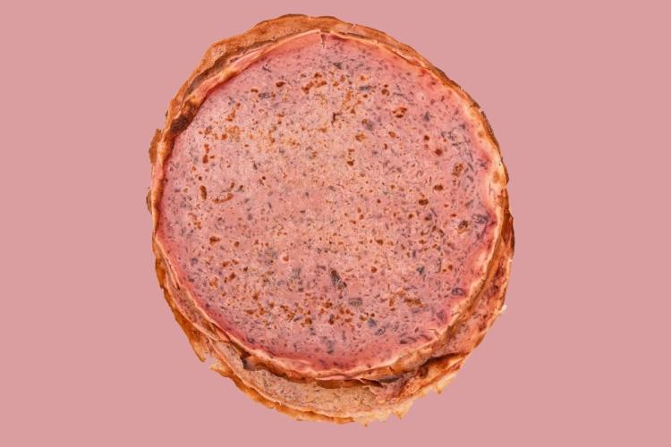 Tortitas rosadas estilo crêpe francés con trocitos de fruta y chocolate rallado.